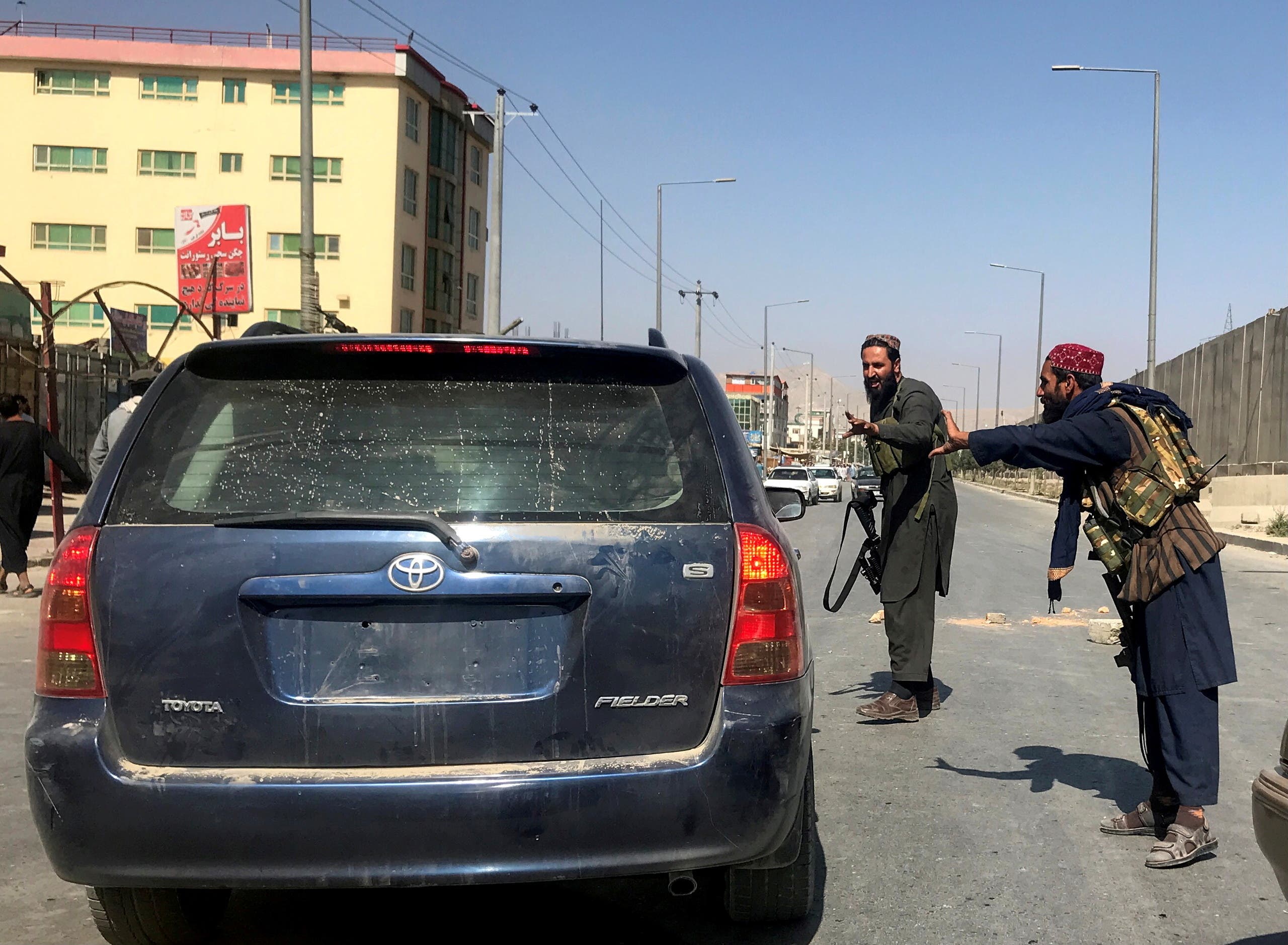 عناصر من طالبان يستوقفونسيارة في كابل لتفنيشها